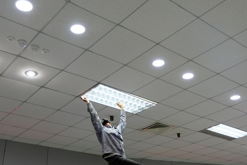 En person som bytter lys i taket